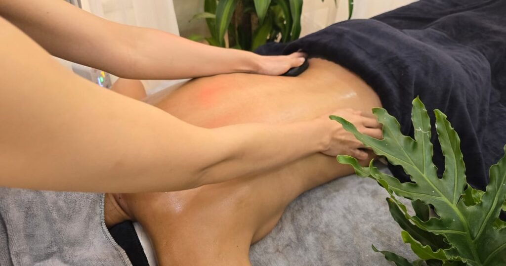 Kỹ thuật viên massage trị liệu vùng lưng cho khách tại Quận 1
