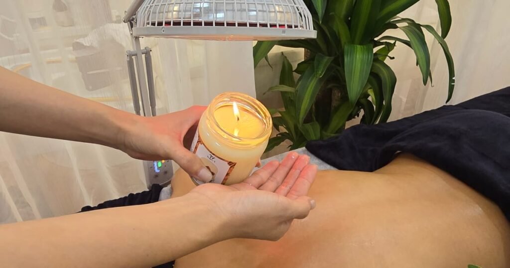 Kỹ thuật viên rót nến dưỡng ấm ra tay trước khi massage thư giãn