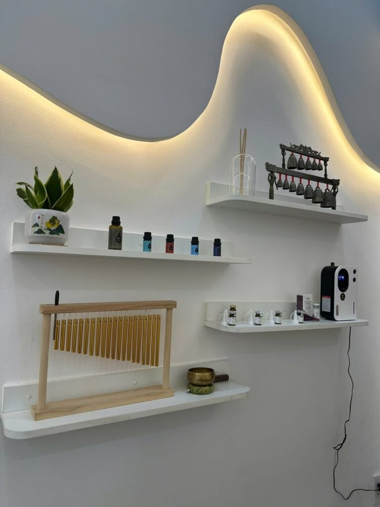 Shelves of treatment oils and spa tools under warm light at Chạm Spa