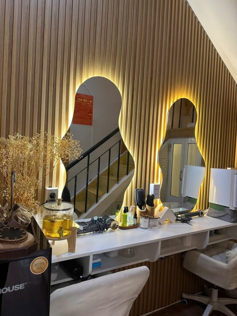 The mirrored vanity area at Chạm Spa with warm wood panelling and skincare products